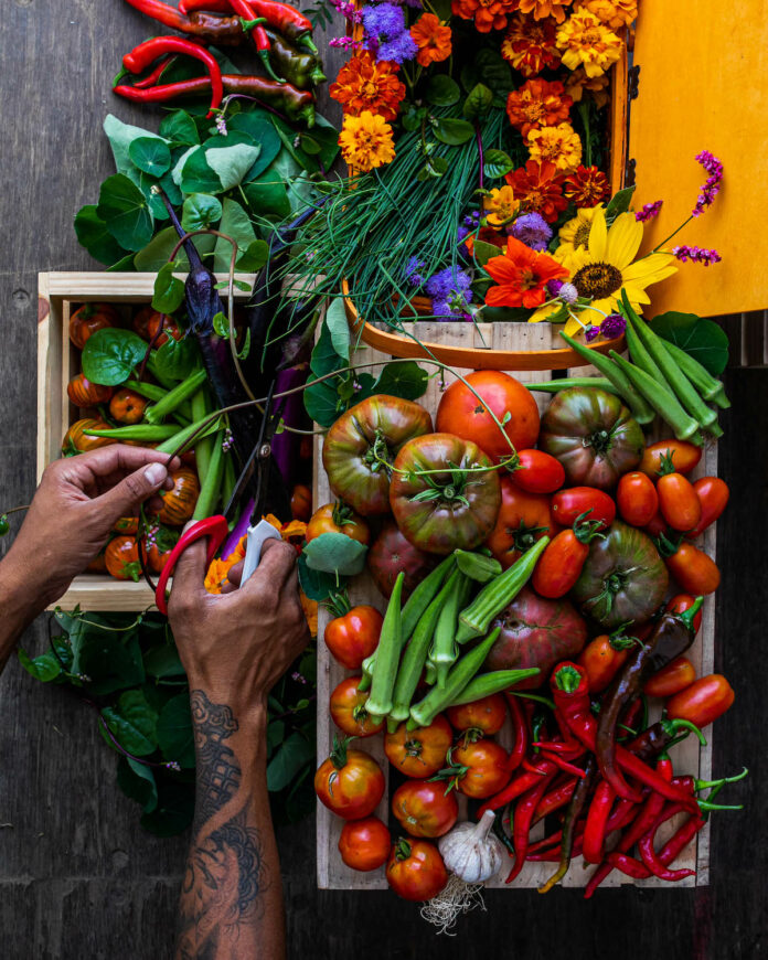A colorful collection of fruit, veggies, and flowers in wooden boxes from AmBoy Urban Collective.