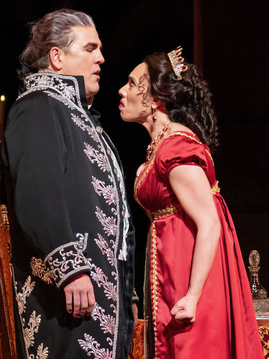 A still from Tosca, staged at the Pittsburgh Opera--a woman in red sings in the face of a man in decadent renaissance garb