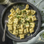 Plated ricotta gnocchi in a roasted green chile sauce topped with parmesan cheese.
