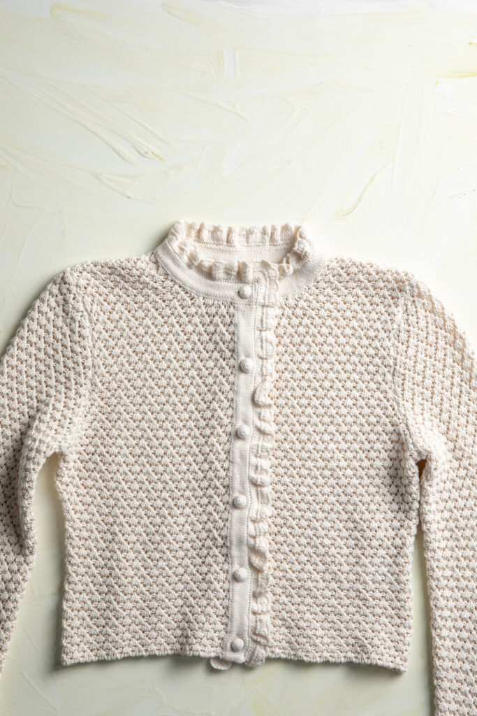 crop cardigan with ruffles at cuffs, neck, and closure. Even the buttons are knitted.