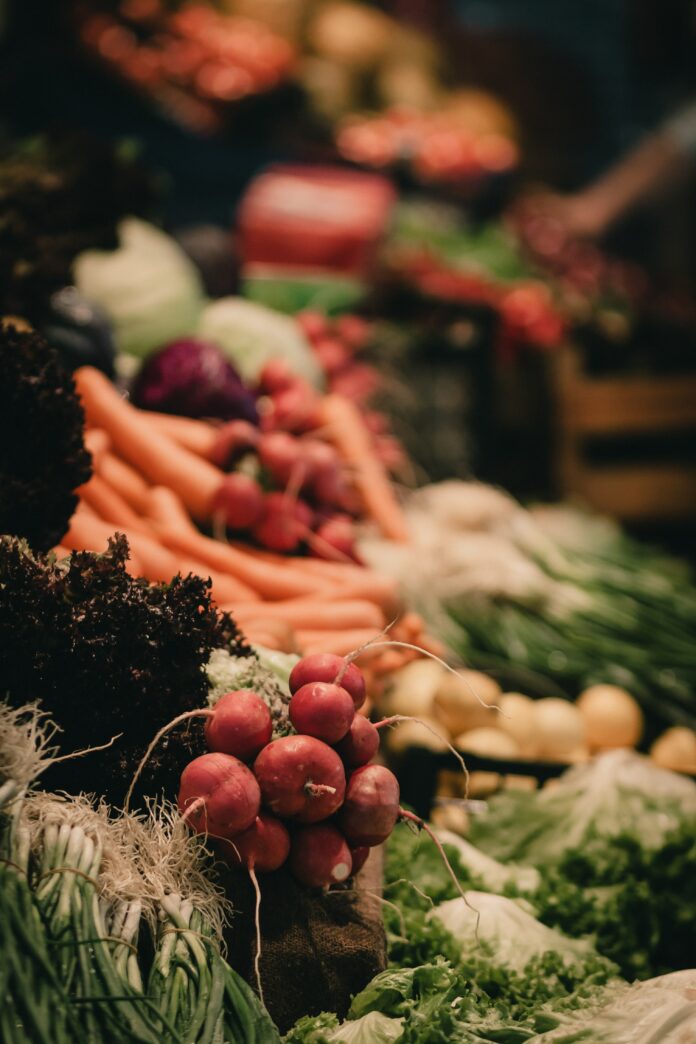 an assortment of fresh fruits and veggies at a farmers market.