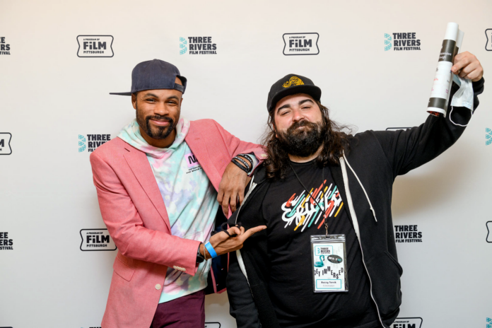 Two men stand on the red carpet of the Three Rivers Film Festival.