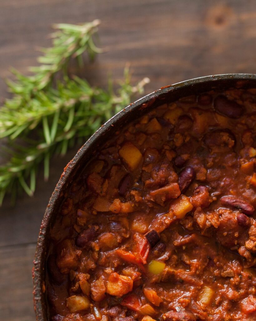 An aerial view of a bowl of chili, red in color