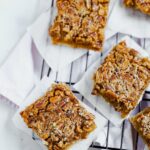 An aerial shot of four pecan pie bars sitting on a wire cooling rack.