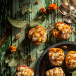 Flat-lay image of apples filled with caramel baked rice pudding on a weathered table. Caramel Apple Rice Pudding Recipe