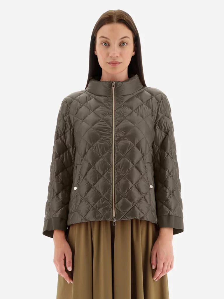 A women with a short quilted jacket on over a dress or skirt.