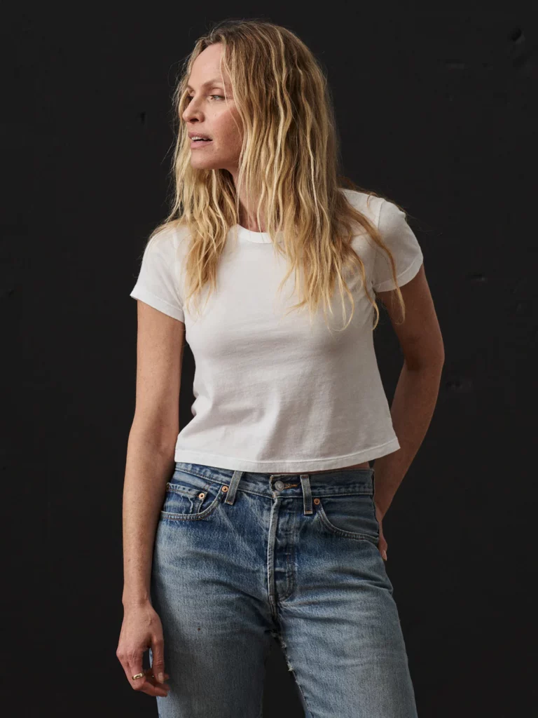 A blonde woman in a white t-shirt with blue jeans.