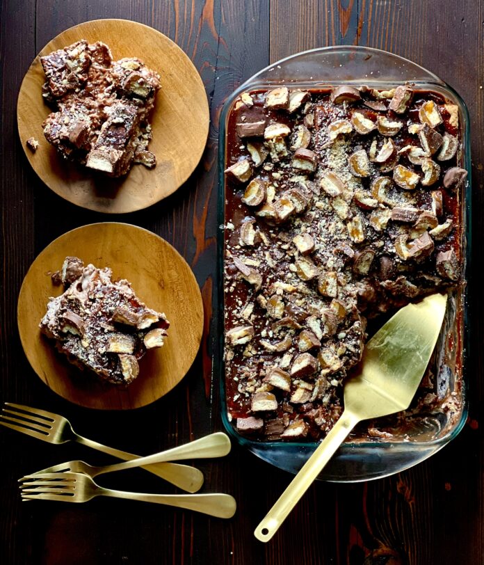 An aerial view of a candy cake with two pieces cut out and put on brown plates