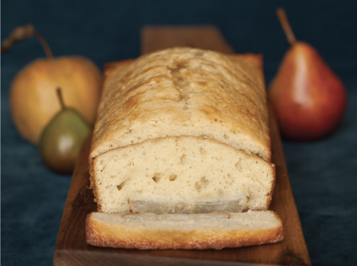 A light brown loaf of poundcake surrounded by three kinds of pears. Pear Poundcake Recipe