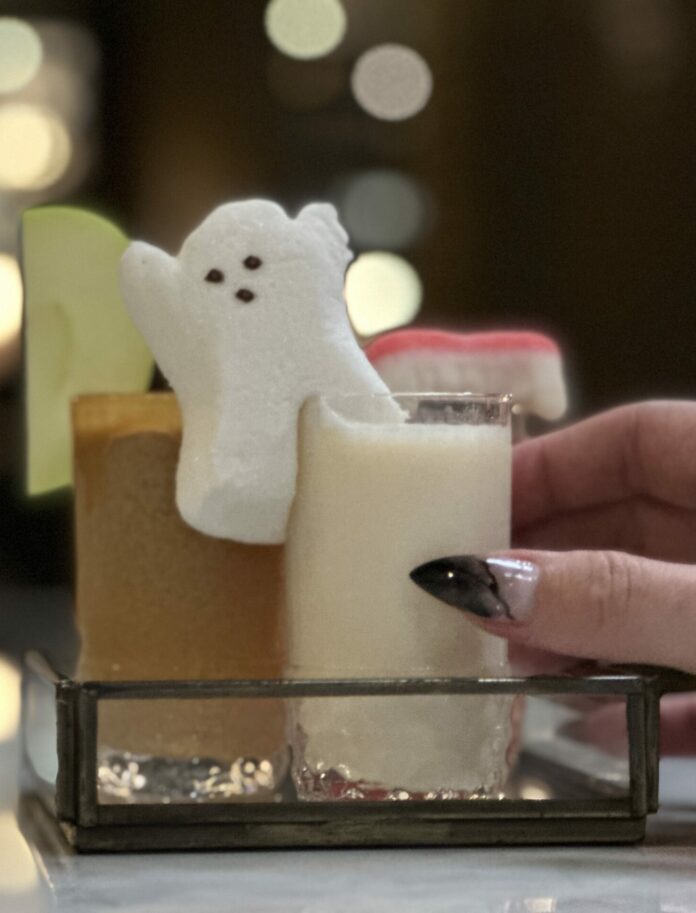 Two shots, one brown one white, with a ghost marshmallow sitting in between. pittsburgh fall cocktail