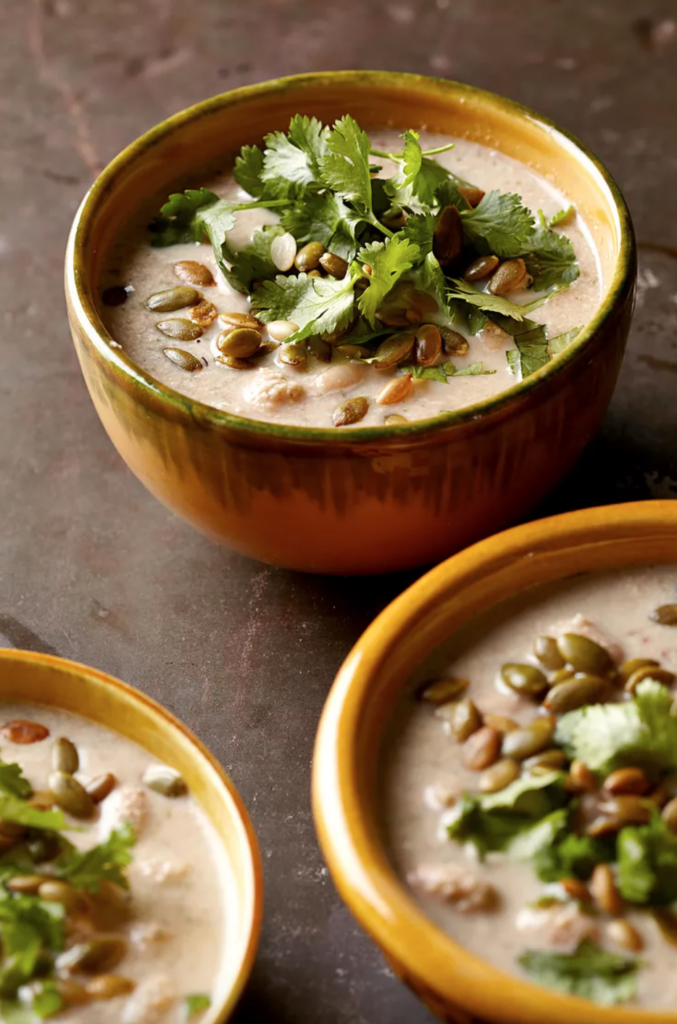 Pumpkin seed soup in colorful bowls garnished with parsley. 