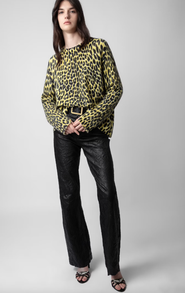 A brunette woman modeling a cheetah print shirt.