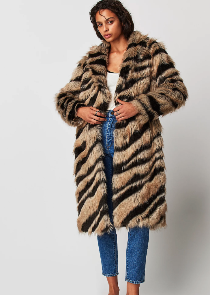 A dark haired woman models a tiger faux fur coat.