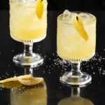 Two light yellow drinks in rocks glasses. Penicillin Cocktail