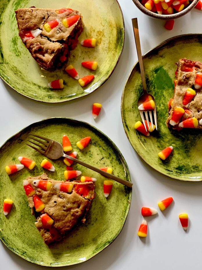 Three green plates with slices of Candy Corn Blondies on top.