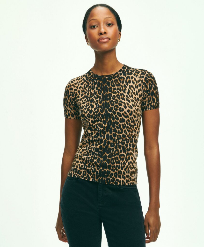 A woman models a leopard print shirt and black pants.
