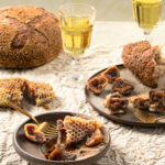 A tempting culinary composition: Millet Porridge Bread topped with luscious Chicken Liver Mousse and rehydrated figs, paired with a rich Amarone wine from Italy's countryside.