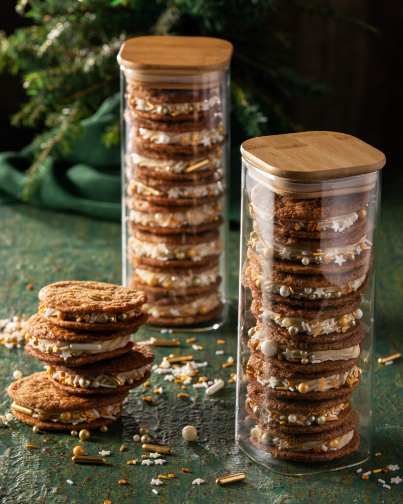 Stacks of homemade Gingerbread Sandwich Cookies on a green table.