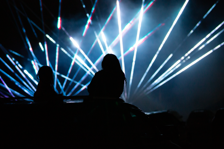 A rear view of people watching a laser light show.