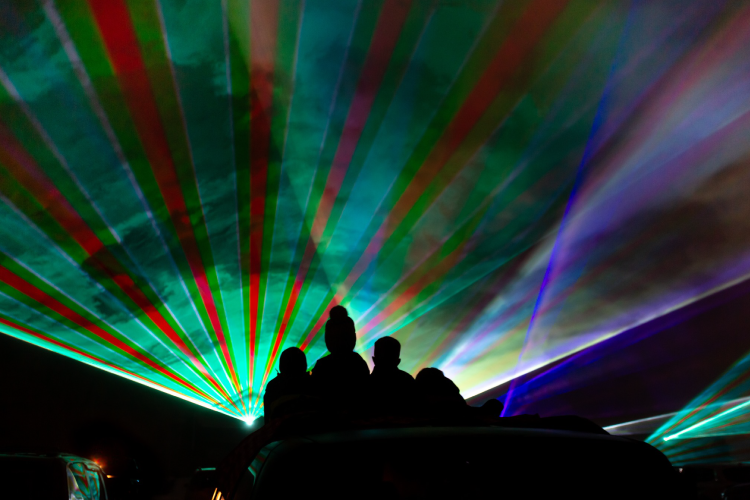 Rear view of a family watching a laser light show.