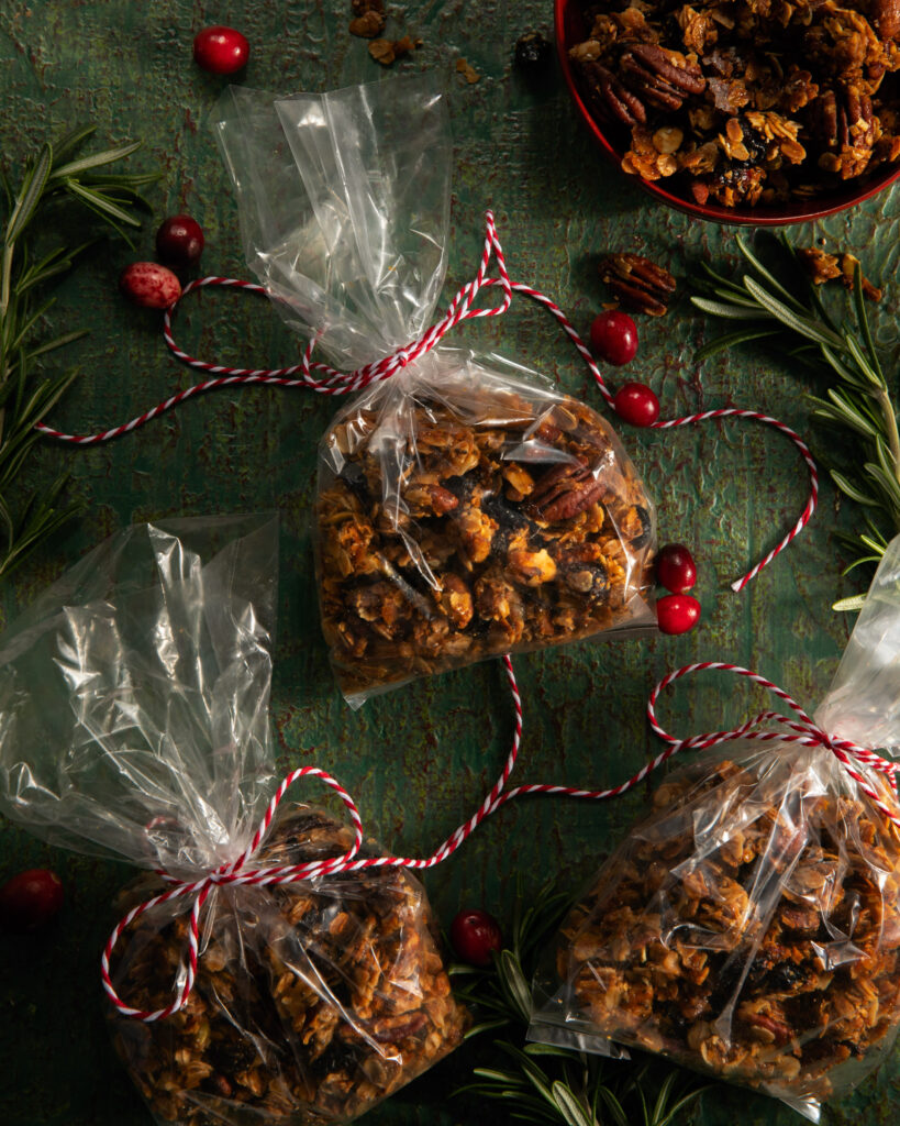 A small plastic bag filled with a Holiday Granola Recipe and tied with red ribbon.