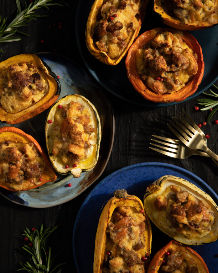 Bread Pudding Stuffed Squash with Savory Black Truffle Three different shades of blue plates with bread pudding stuffed small halved squashed with rosemary and red peppercorn garnish around the plates