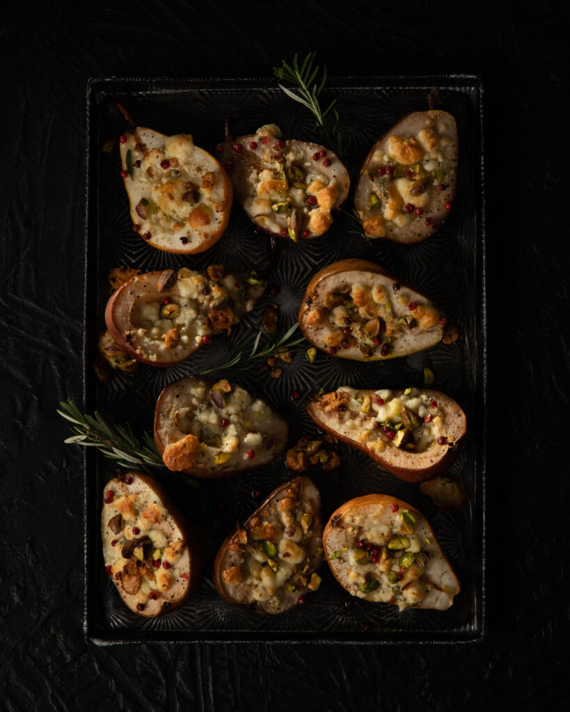 roasted pears with toppings served on a black textured tray