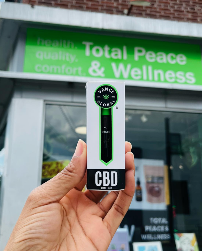 A piece of CBD product held in front of a CBD Pittsburgh Store front.