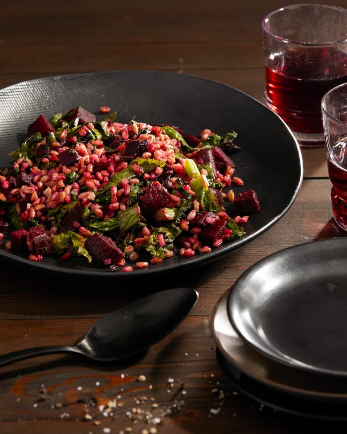 Farro served with Beets, Greens & Ginger Dressing in a skillet with a spoon on the side