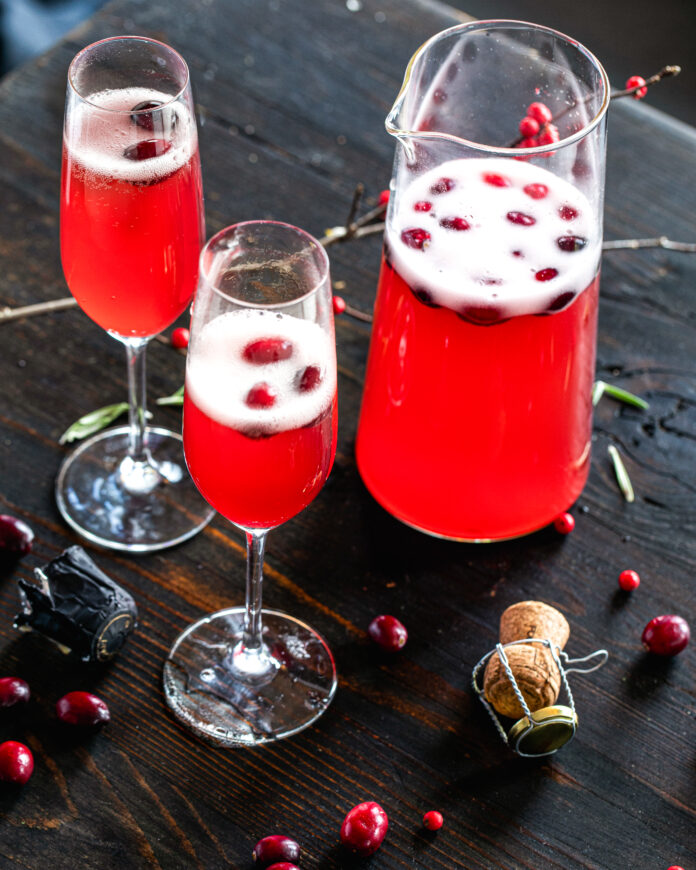 The Ultimate Cranberry Mimosa Sparkling cranberry mimosa in a champagne flute, crafted with homemade cranberry juice for a vibrant, festive sip.