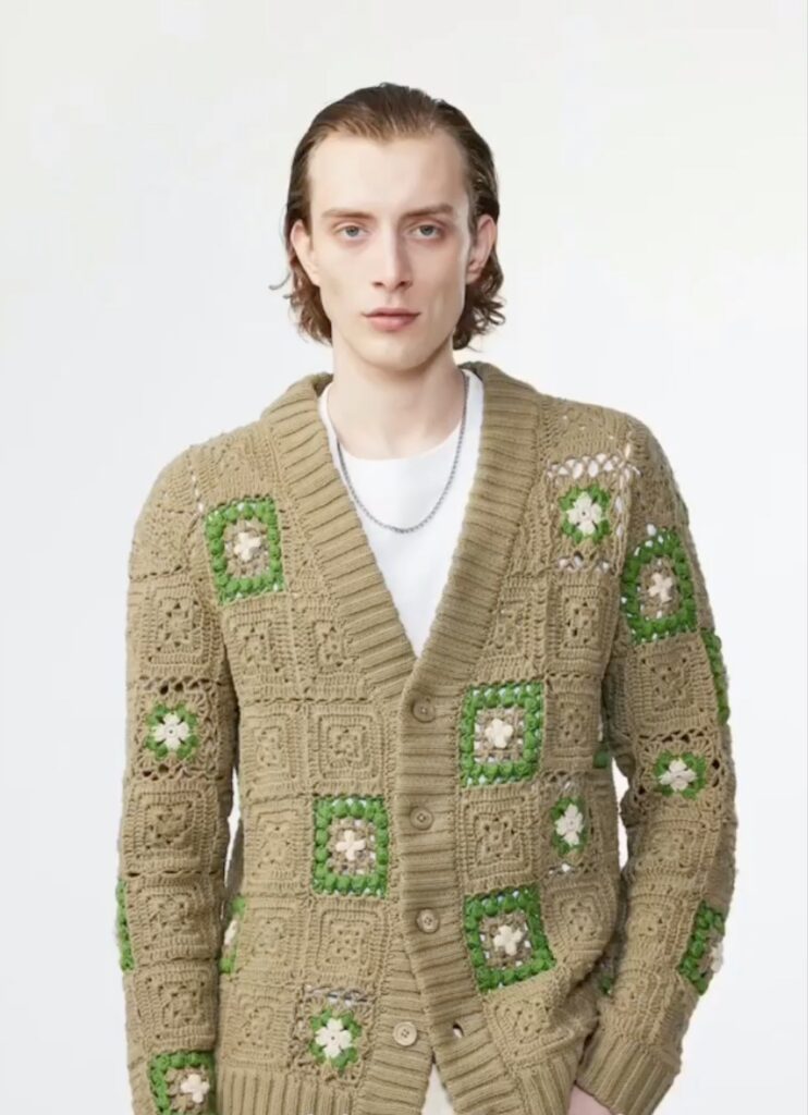 A man in a sage green sweater with dark green patches from Moda in Shadyside, Pittsburgh
