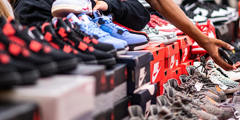 Colorful sneakers lined up in a row with boxes beneath them.