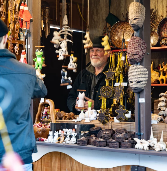 Peoples Gas Holiday Market A man runs a vendor booth at the Peoples Gas Holiday Market in Pittsburgh standing behind a bunch of puppets.