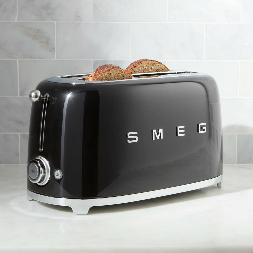 A black Smeg toaster with toast peaking out from inside on a white counter.