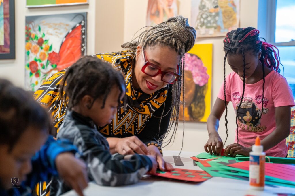 A woman assists two children in an activity at a gallery in Pittsburgh.