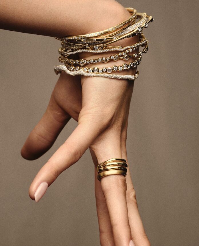 A women's hand adorned with gold rings and bracelets