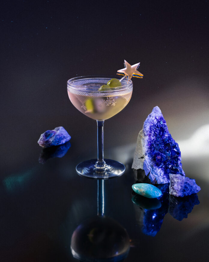 LPetrilla_3-VirgoCosmicCocktails-1912 A gin Martini cocktail for Virgo on a tabletop with a star topper in the glass and purple amethyst on the table.
