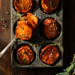 Sweet potato stacks on in a pan, glistening orange