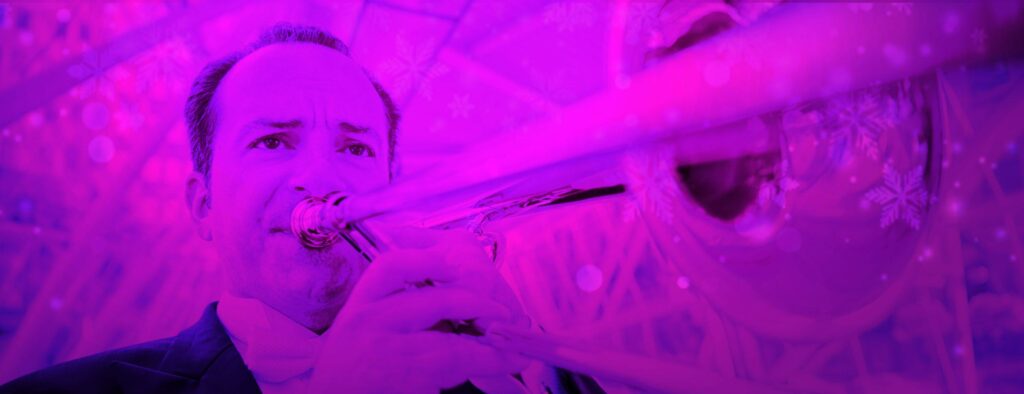 An up-close, purple-colored photo of a man playing trombone.