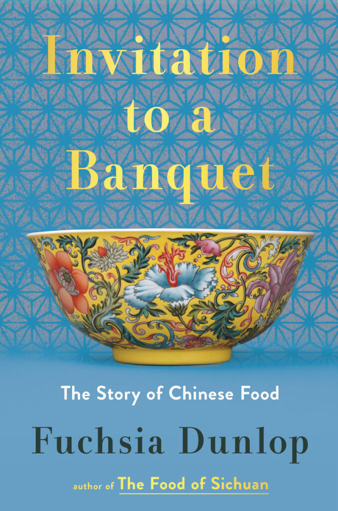 A brightly painted oriental yellow bowl sits against a blue patterned background to make the cover of the cookbook.