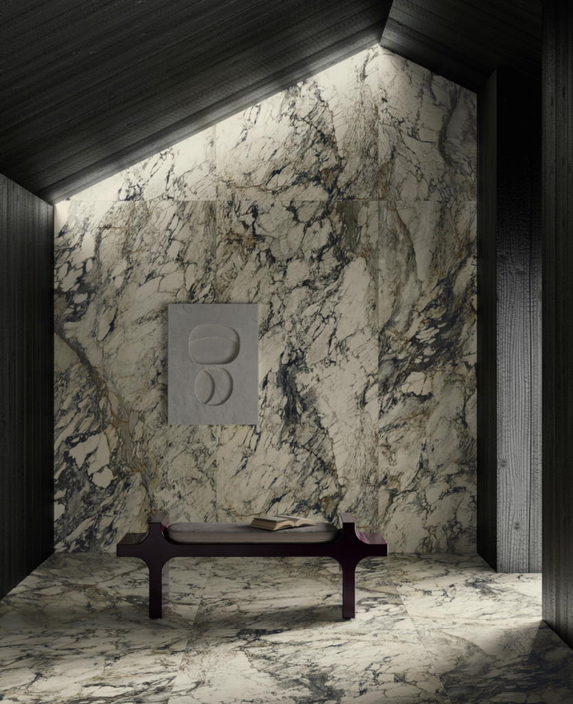 Dark marble grey stone tiles layer a small room with just a bench in it and light creeping in through the right side doorway.