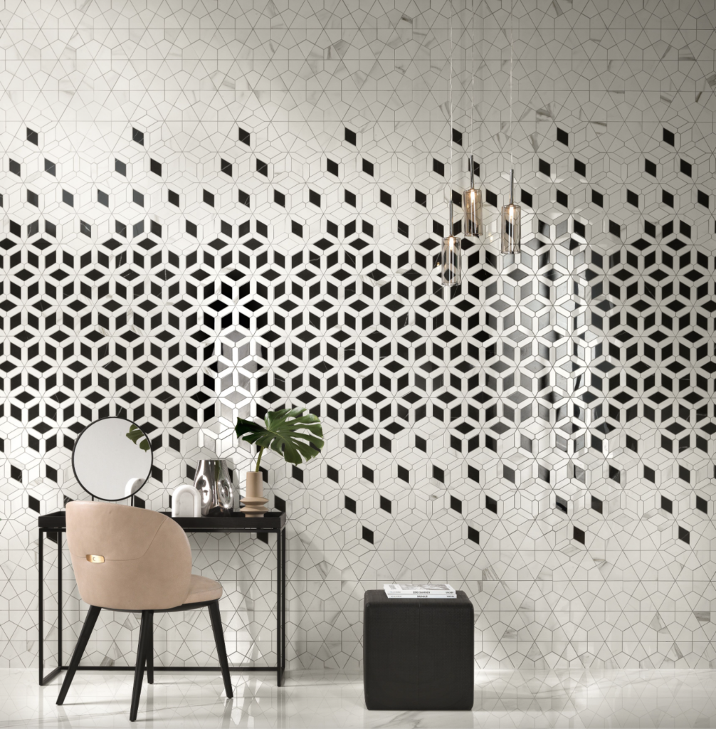 A white room with patterned black tiles all over the walls and a vanity desk off to the left side with a beige chair and black small table beside it.