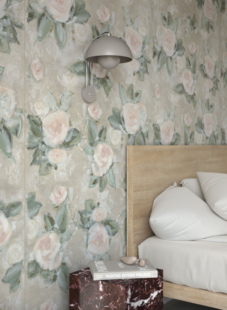 A soft painted tile of pale pink roses lines the wall next to a bed with a light wood headboard.