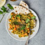 curried lentil salad served in a white ceramic plate with two tortillas