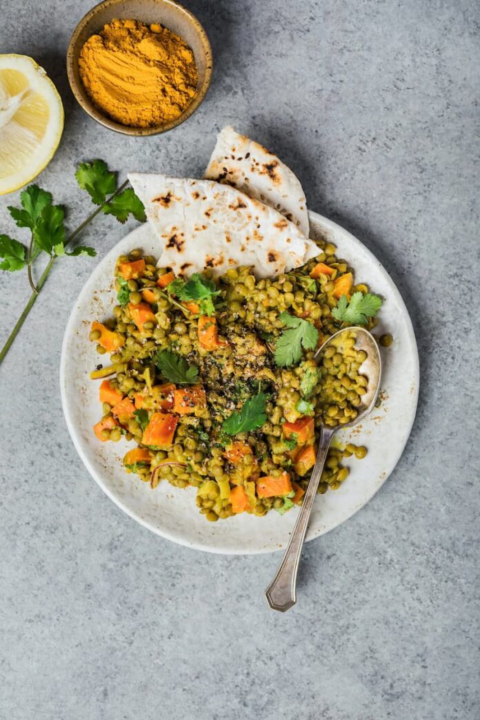 curried lentil salad served in a white ceramic plate with two tortillas
