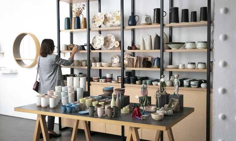 A woman browses shelves of pottery and vases at Empreintes design shop in Paris