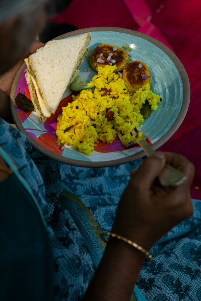 A Bombay-Style Sandwich served on a ceramic plate with lemon rice and aloo tikki