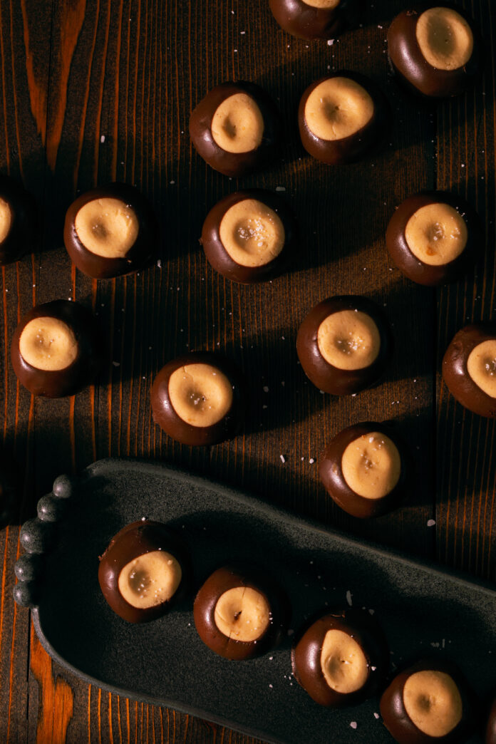 11 buckeyes sit spread apart on a wooden table