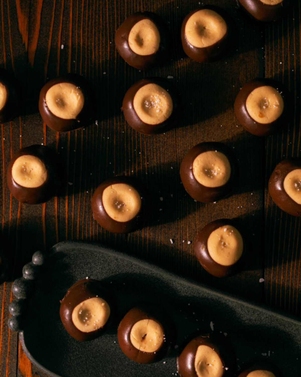 11 buckeyes sit spread apart on a wooden table