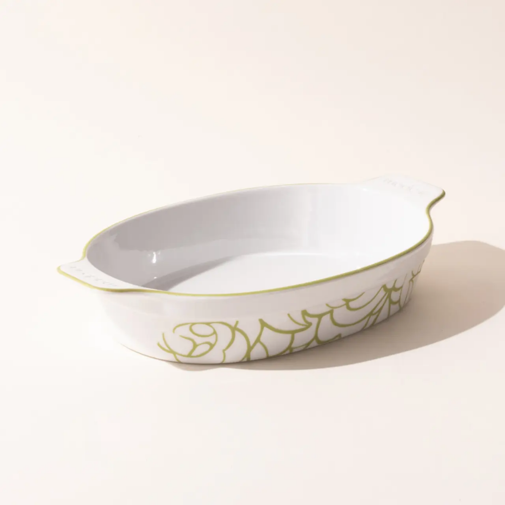 A rounded, oval porcelain baking dish by made in cookware with little yellow line designs on the outside.